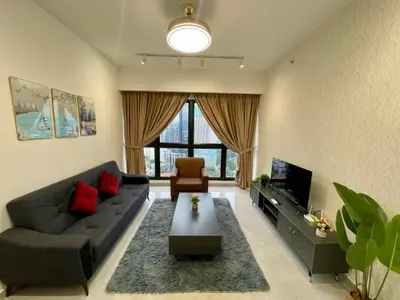 a living room with a couch and a tv at Bukit Bintang Service Apartment in Kuala Lumpur