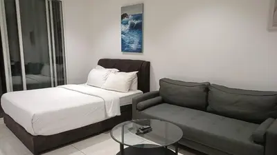 a living room with a couch and a bed at Family Suites at TRION KL in Kuala Lumpur