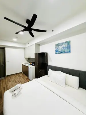 a bedroom with a white bed with a ceiling fan at Agile Bukit Bintang TRX By RUP Suites in Kuala Lumpur