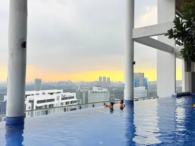 a pool on the roof of a building with people in it at The luxe by Kuala Lampur City in Kuala Lumpur