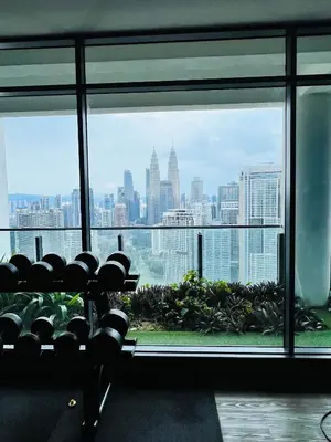 a gym with a view of the city from a window at Sky property by klcc in Kuala Lumpur