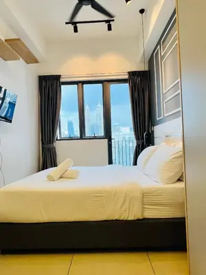 a bedroom with a large bed with a large window at Sky property by klcc in Kuala Lumpur