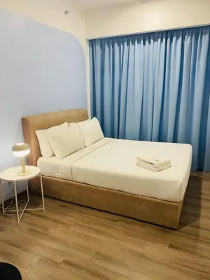 a bed in a room with a blue curtain at agile residence in Kuala Lumpur