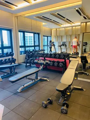 a gym with lots of exercise equipment and a man in the background at agile residence in Kuala Lumpur