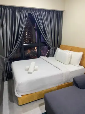 a bedroom with a large white bed with a window at agile residence in Kuala Lumpur