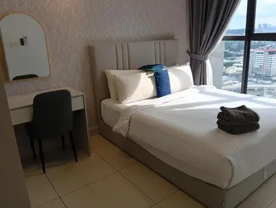 a hotel room with a bed and a desk and a window at Sky Residence at TRION KL in Kuala Lumpur