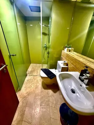 a green bathroom with a sink and a shower at Sky Suites Klcc By Bukit Bintang in Kuala Lumpur