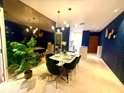a dining room with a table and chairs and a plant at Sky Suites Klcc By Bukit Bintang in Kuala Lumpur