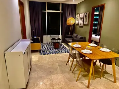 a living room with a table and a dining room at Sky Suites Klcc By Bukit Bintang in Kuala Lumpur