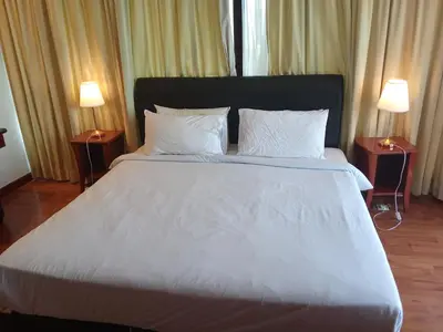 a bedroom with a large bed with white sheets and pillows at BTS Service suite at time square in Kuala Lumpur