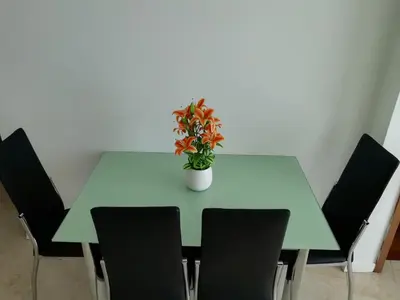 a green table with chairs and a potted plant on it at Vortex Suites klcc By MY FRAGRANCE in Kuala Lumpur