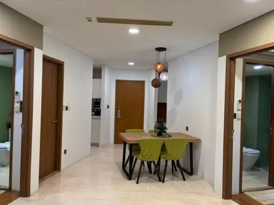 a dining room with a table and green chairs at Vortex Suites klcc By MY FRAGRANCE in Kuala Lumpur