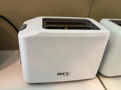 a white toaster sitting on a counter next to two toasters at Vortex Suites klcc By MY FRAGRANCE in Kuala Lumpur
