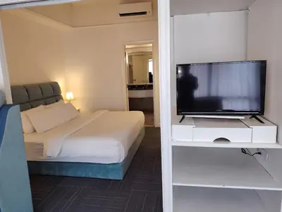 a bedroom with a bed and a flat screen tv at Time square midnight suites KL in Kuala Lumpur