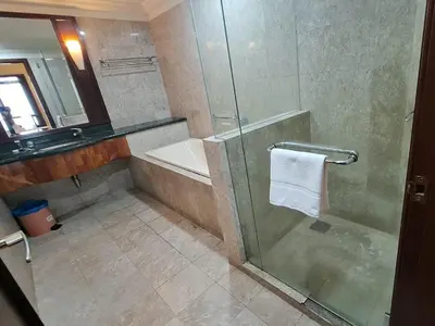 a bathroom with a shower and a tub and a sink at Time square midnight suites KL in Kuala Lumpur