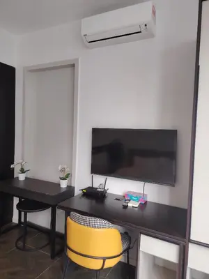 a desk with two chairs and a television on a wall at Scarletz Suites KLCC by near twin tower in Kuala Lumpur