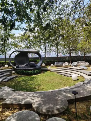 a sculpture in a park with rocks and trees at Scarletz Suites KLCC by near twin tower in Kuala Lumpur