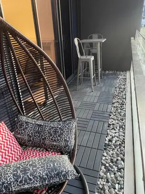 a wicker chair sitting on a balcony with a table at 3BR family friendly Apartment at The Elements Ampang Kuala Lumpur in Kuala Lumpur
