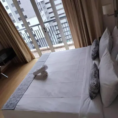 a large white bed in a room with a large window at Abadi Inn in Kuala Lumpur