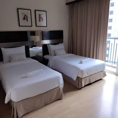 a hotel room with two beds and a window at Abadi Inn in Kuala Lumpur
