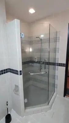 a shower with a glass door in a bathroom at Abadi Inn in Kuala Lumpur