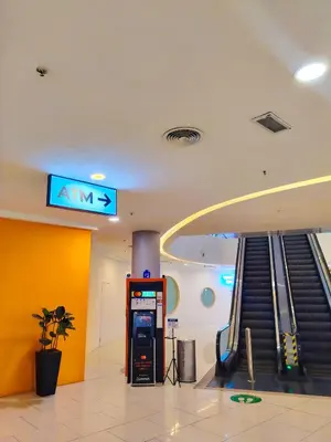 an atm machine in a building with an escalator at Rooftop Pool At Majestic Residence in Kuala Lumpur