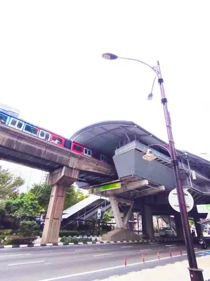 a train on a bridge over a street at Rooftop Pool At Majestic Residence in Kuala Lumpur