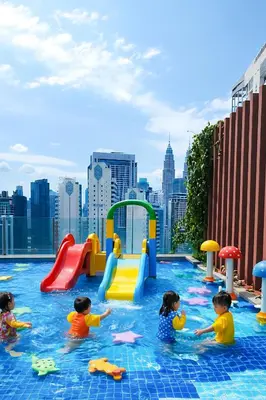 a group of children playing in a pool with a city in the background at Rooftop Pool At Majestic Residence in Kuala Lumpur