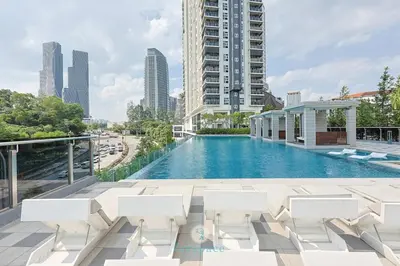 a swimming pool with white chairs and a building at Met 1 Mont Kiara - 3 min to Publika Mall - 2B2B for 4 in Kuala Lumpur