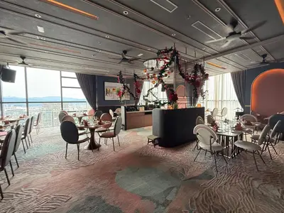 a dining room with tables and chairs and large windows at KLCC VIEW RESIDENC, I M P E R I A L , By LUXORA in Kuala Lumpur