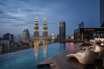 a view of the kuala lumpur city skyline from a rooftop pool at KLCC VIEW RESIDENC, I M P E R I A L , By LUXORA in Kuala Lumpur