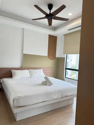 a bedroom with a white bed with a ceiling fan at Bukit Bintang Casa By Eryan Guest House in Kuala Lumpur