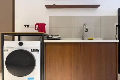 a kitchen with a washing machine and a sink at Majestic Residence KLCC by Luxe in Gua Sai