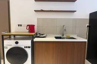 a kitchen with a washing machine and a sink at Majestic Residence KLCC by Luxe in Gua Sai
