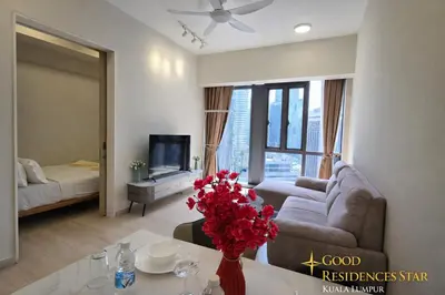 a living room with a couch and a table with flowers at Good Residences at Star KLCC in Kuala Lumpur