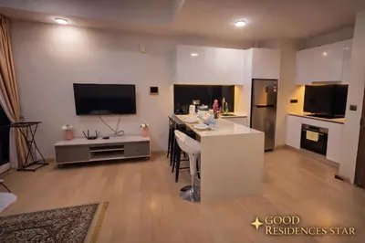 a living room with a kitchen with a table and a tv at Good Residences at Star KLCC in Kuala Lumpur