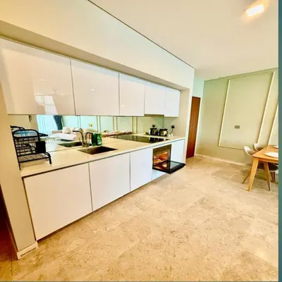 a kitchen with white cabinets and a table at Sky suites klcc by Ryan in Kuala Lumpur