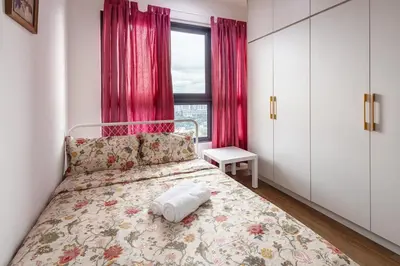 a bedroom with a bed and a window with pink curtains at Kuala Lumpur M Vertica Retro 3BR with Car park in Kuala Lumpur