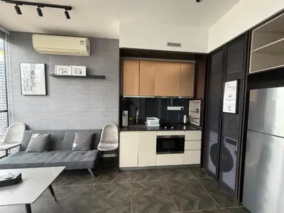 a living room with a couch and a kitchen at Metahome at Scarletz suites KLCC in Kuala Lumpur