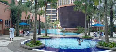 a large swimming pool in a hotel with palm trees at Town suites Times Square in Kuala Lumpur