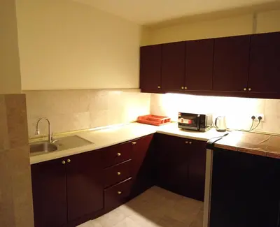 a kitchen with brown cabinets and a sink at Town suites Times Square in Kuala Lumpur