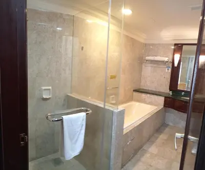 a bathroom with a shower and a tub and a sink at Town suites Times Square in Kuala Lumpur