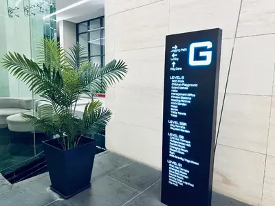 a sign in front of a building with a potted plant at Eaton Residences KL City Center in Kuala Lumpur