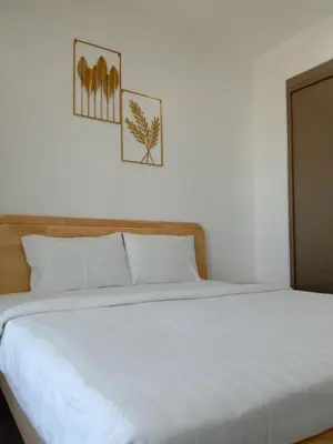 a white bed with two pictures on the wall at Agile Bukit Bintang Sleepy in Kuala Lumpur
