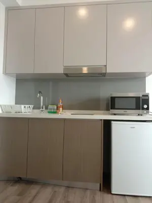 a kitchen with white cabinets and a microwave at Agile Bukit Bintang Sleepy in Kuala Lumpur