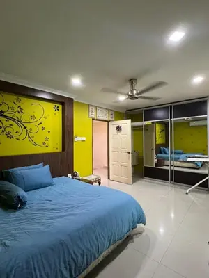 a bedroom with a blue bed and a yellow wall at Gombak Fatin Homestay in Kuala Lumpur
