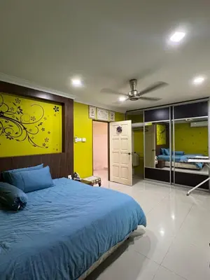 a bedroom with a blue bed and a yellow wall at Gombak Fatin Homestay in Kuala Lumpur