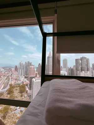 a bedroom with a bed and a large window at Poshpack Skyline Hostel in Kuala Lumpur