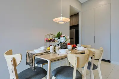 a dining room with a wooden table and chairs at Elegant Skyline Suite # Datum Jelatek near KLCC in Kampong Datok Keramat