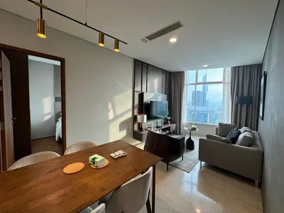 a living room with a table and a living room with a couch at Tomato Homestay By Sky Suites Klcc in Kuala Lumpur
